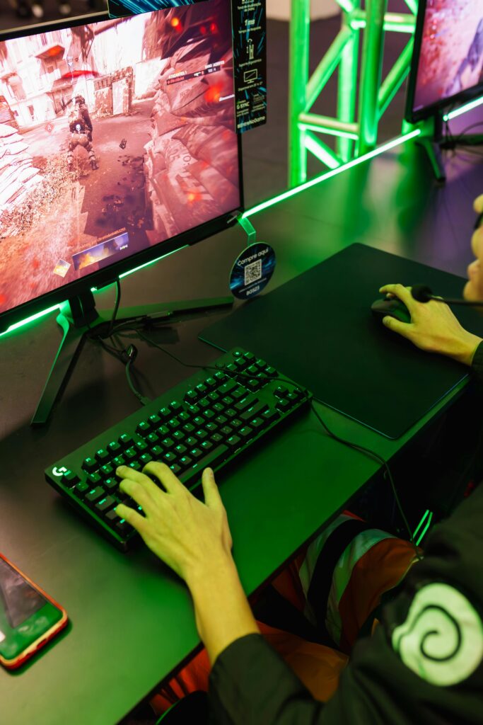 A focused gamer playing an action-packed video game on a desktop setup with RGB lighting.