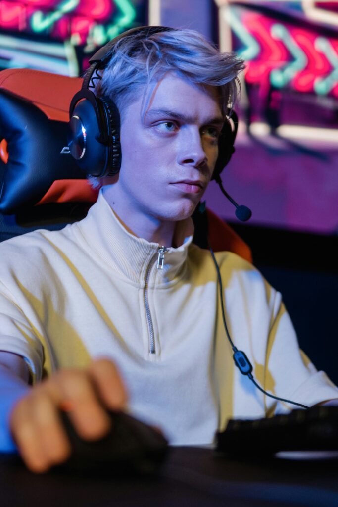 Young man in a headset intensely focused while gaming indoors.