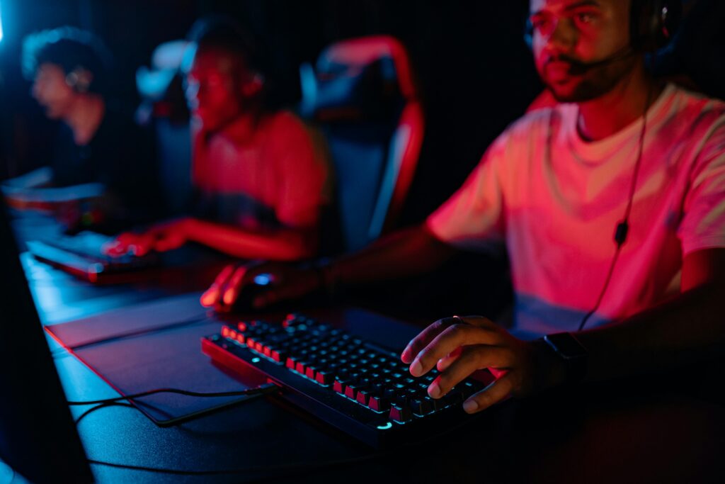 Diverse group of gamers focused on a competitive esports match in a dimly lit arena.